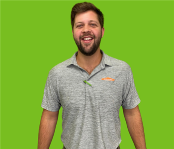 Male Employee with Brown Hair Smiling on Green Background