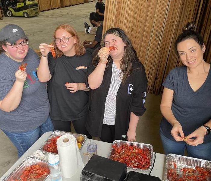 Four female SERVPRO employees eating crawfish