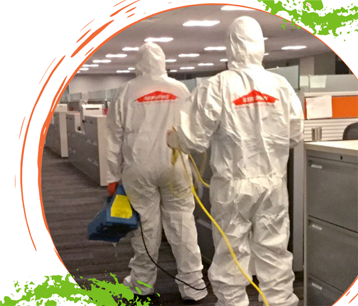 two SERVPRO employees in PPE walking through an office building