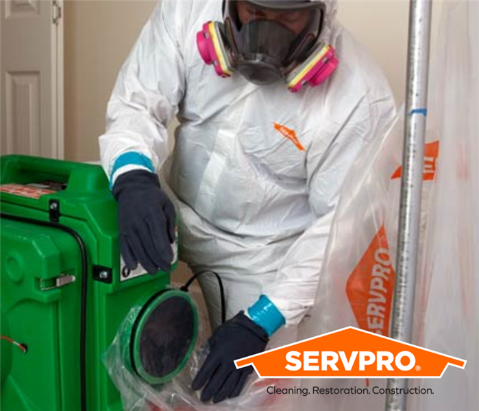SERVPRO employee in PPE using green equiptment with SERVPRO logo 