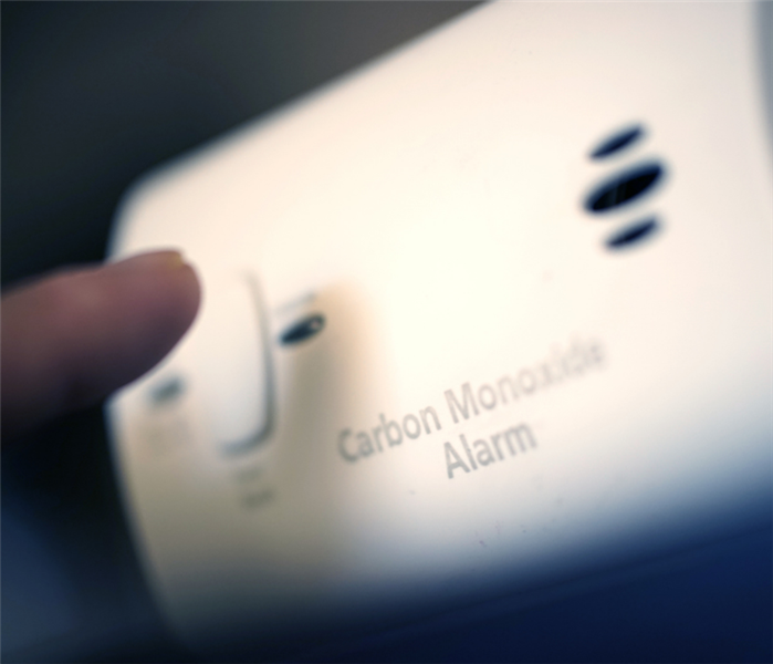 Finger Pressing Carbon Monoxide alarm